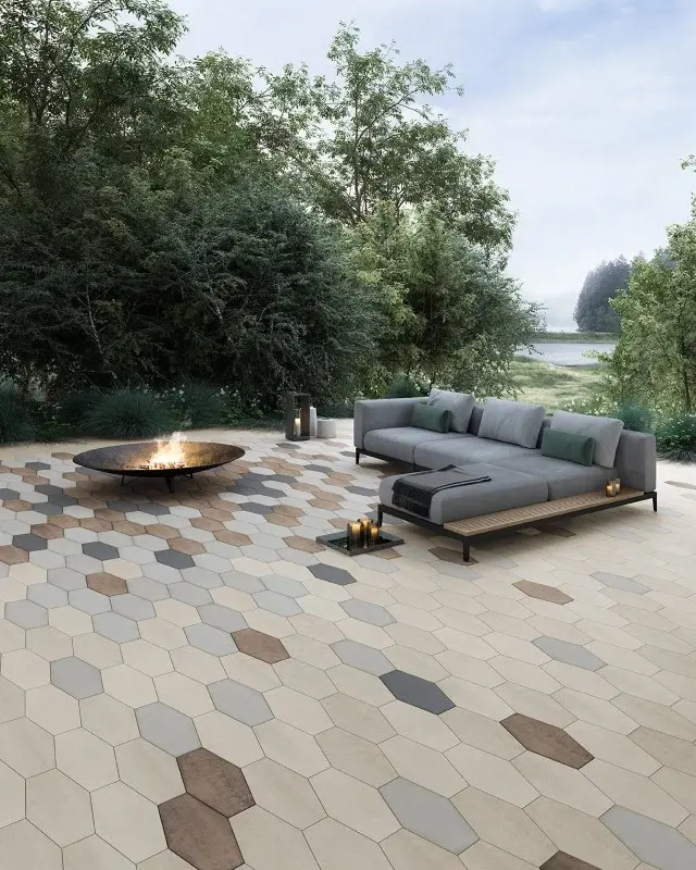 Patio en pavés Hexa beige, brun et gris avec foyer extérieur et mobilier moderne, parfait pour profiter de la vue sur le lac.