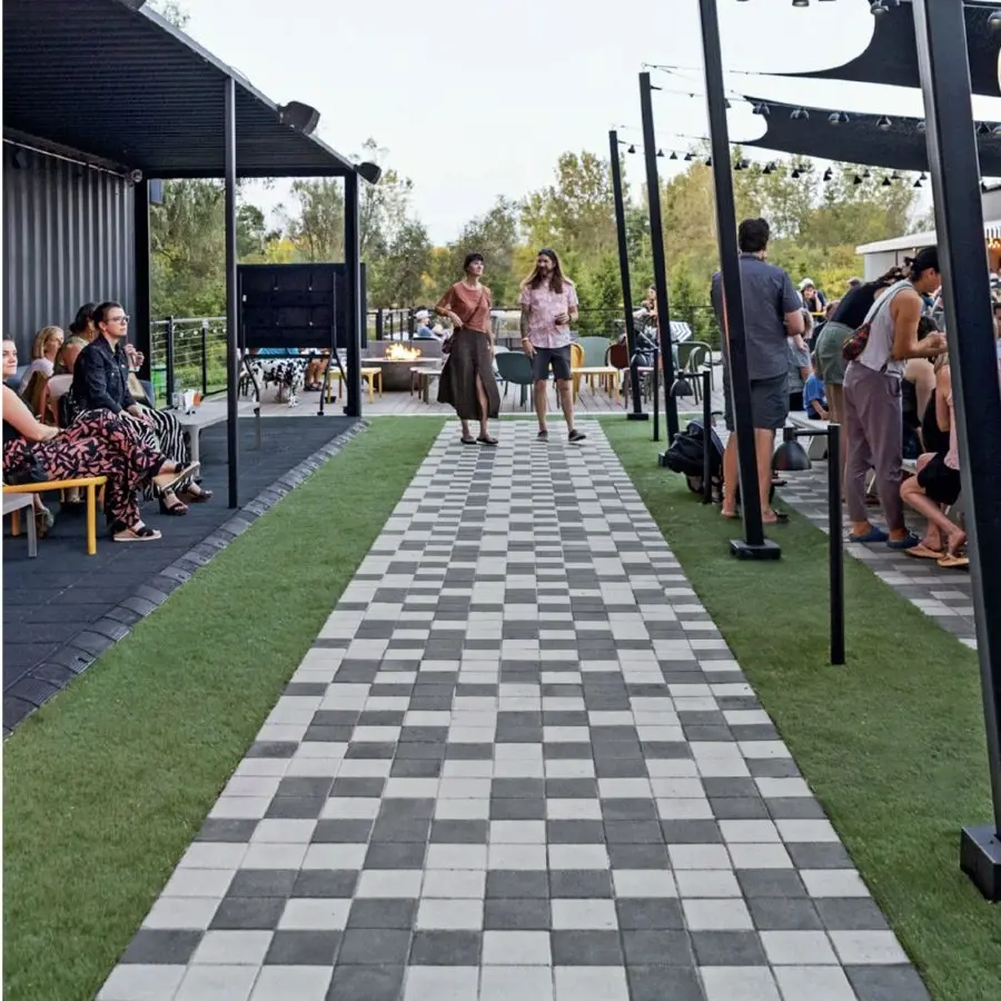 Espace extérieur animé au Yard at Sam Hill avec des pavés de la collection Industria de Techo-Bloc dans un design géométrique audacieux.