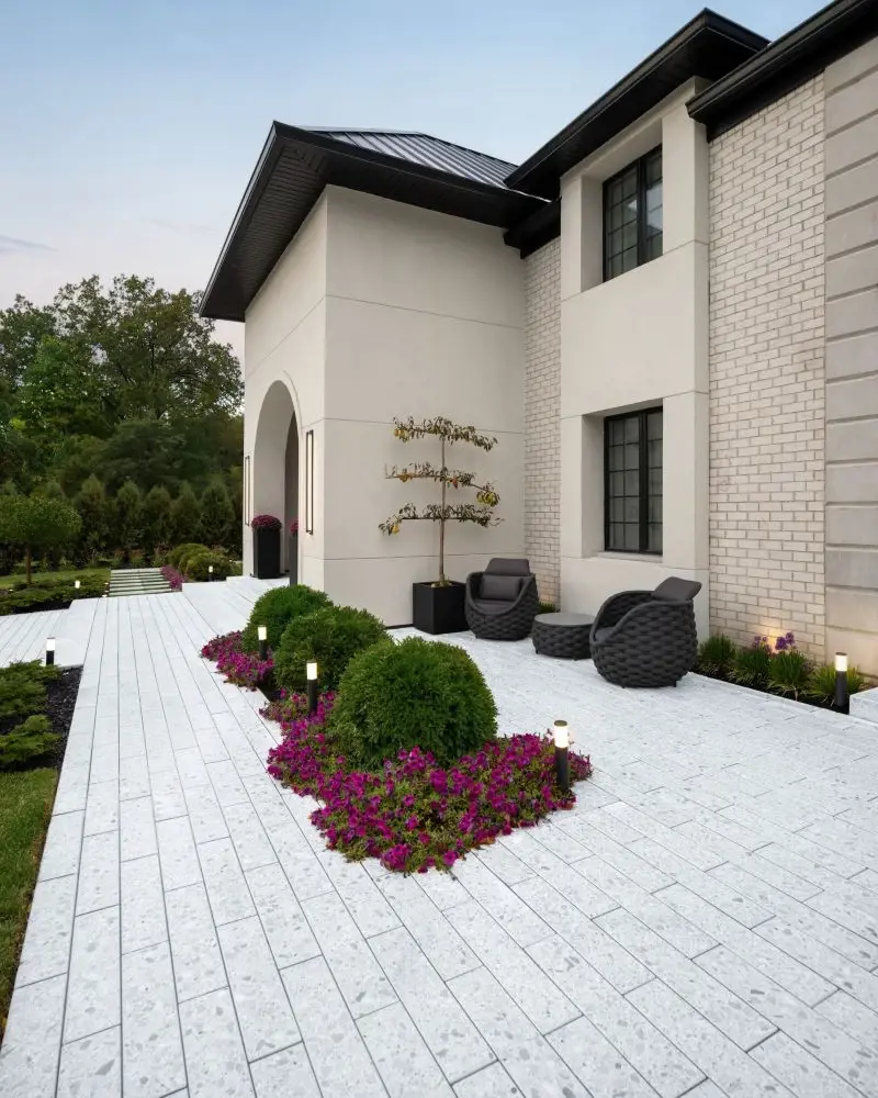 Residential patio designed with light-colored terrazzo pavers, clean lines, and modern landscaping accents.