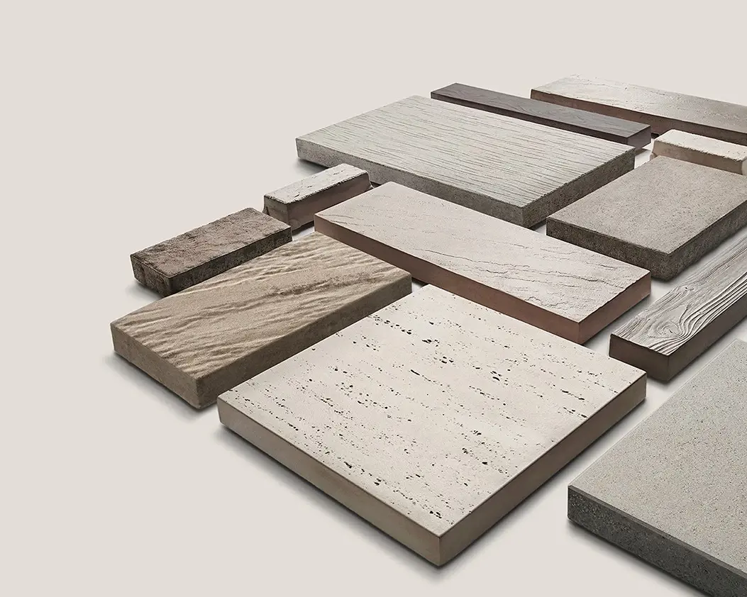 The Sculptura Rectangle firepit from the Sculptura Collection, featuring a clean-lined concrete form with black lava rocks—ideal for contemporary outdoor spaces.