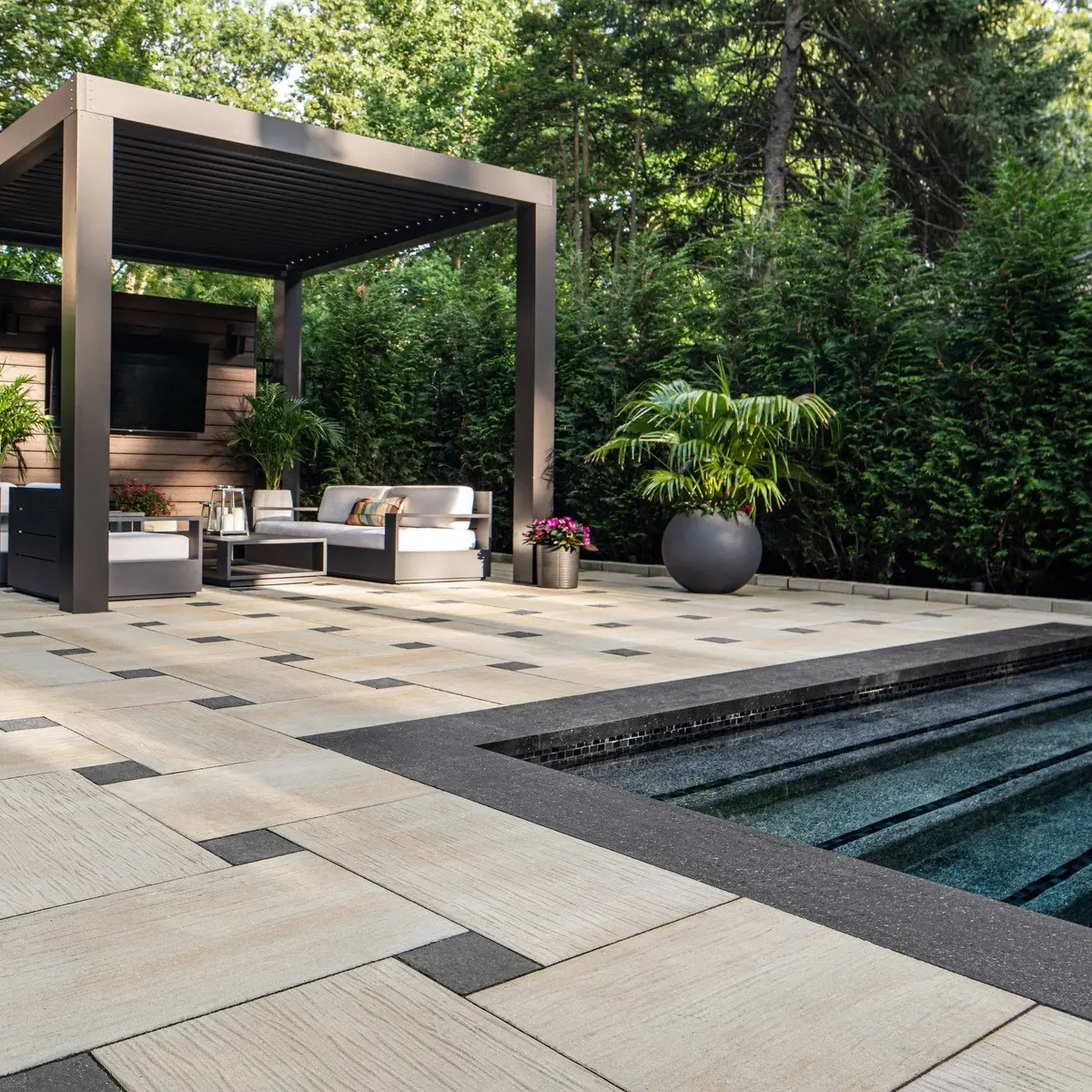 Ocean Grande Slabs by Techo-Bloc in beige, modular pool deck with dark accents, pergola, and white cushioned seating.