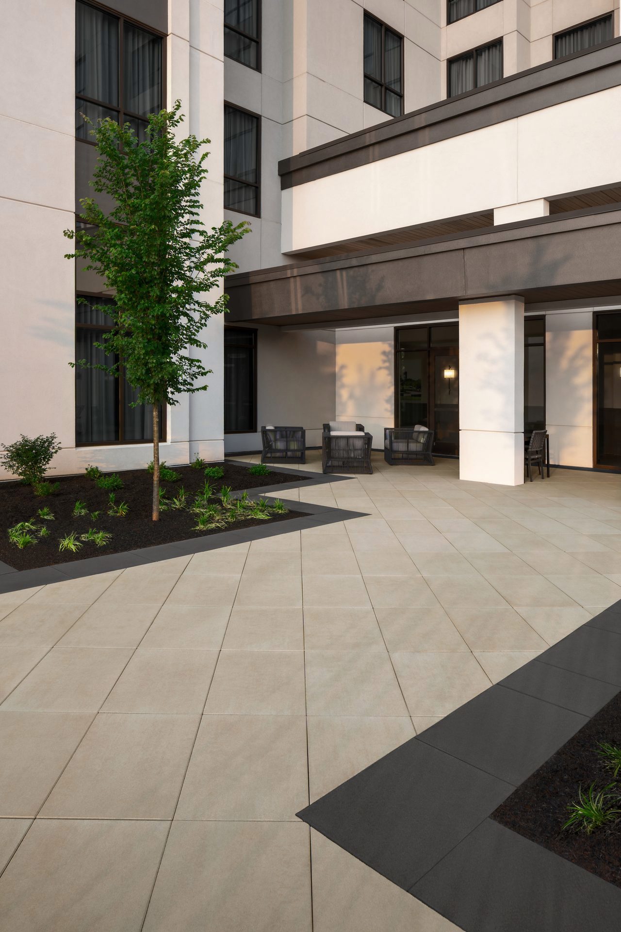 Une allée pavée à l'extérieur de l'hôtel Embassy Suites où on y voit les dalles commerciales Para de Techo-Bloc dans les couleurs noir onyx et beige crème.