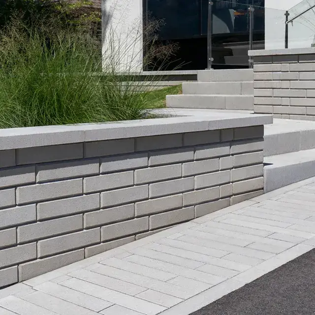 Raffinato Smooth by Techo-Bloc, smooth concrete wall blocks with sleek chamfered edges, adding a luxurious and modern touch to the outdoor space.
