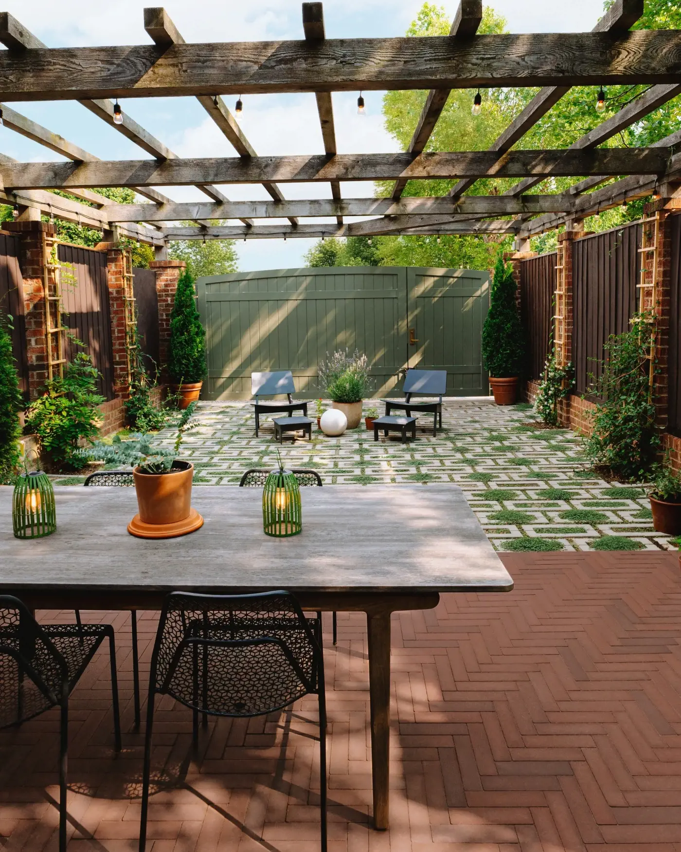 Geometric backyard patio design using Techo-Bloc Aquastorm permeable pavers framed with Westmount pavers, featuring grass joints and modern outdoor seating.