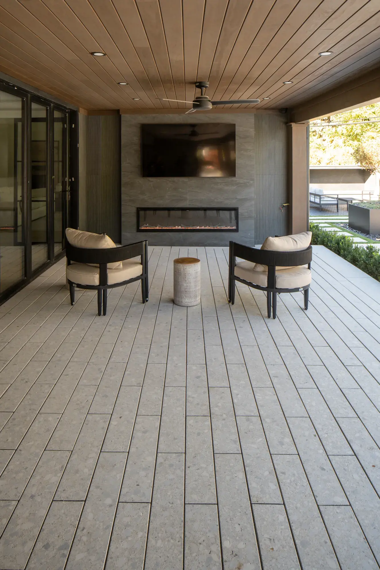 Deux fauteuils près d'un foyer linéaire sur une terrasse-salon en Terrazzo
