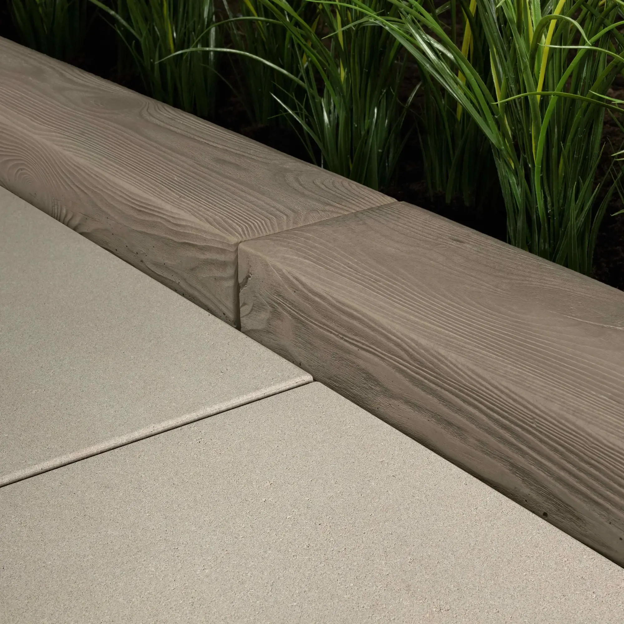 Borealis edging stone in Hazelnut Brandy, close-up of the wood-grain texture on a planter corner