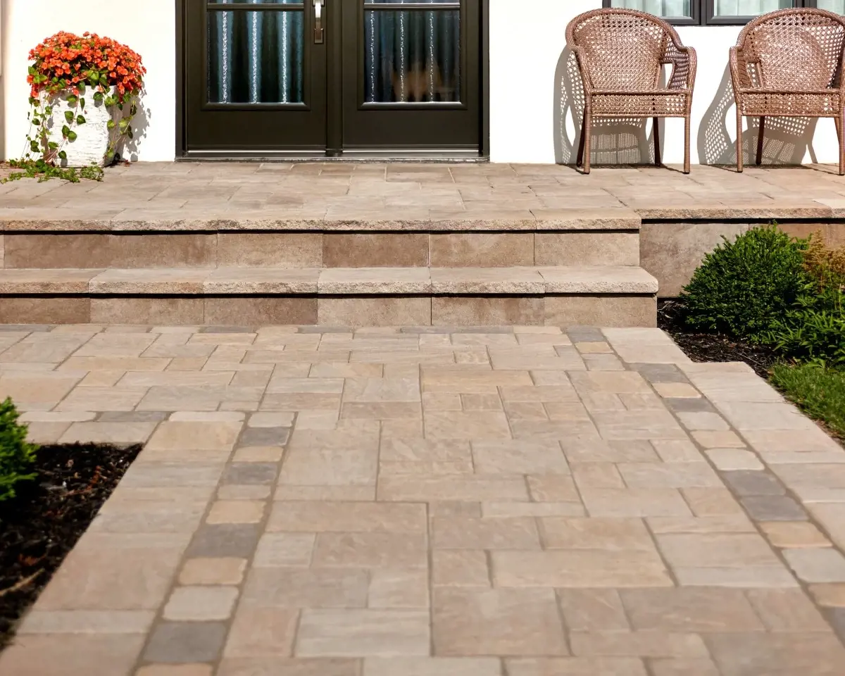 Eva Slate paver by Techo-Bloc in Sandlewood with slate texture, forming a warm-toned walkway leading to a front entrance with border detail.