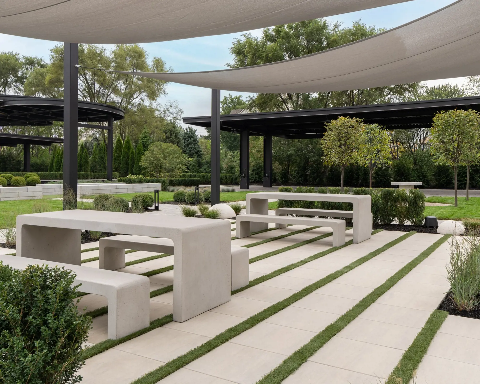 Espace repas du Peace Park avec dalles Industria HD² Smooth de Techo-Bloc en nickel grisé, bancs et zones ombragées.