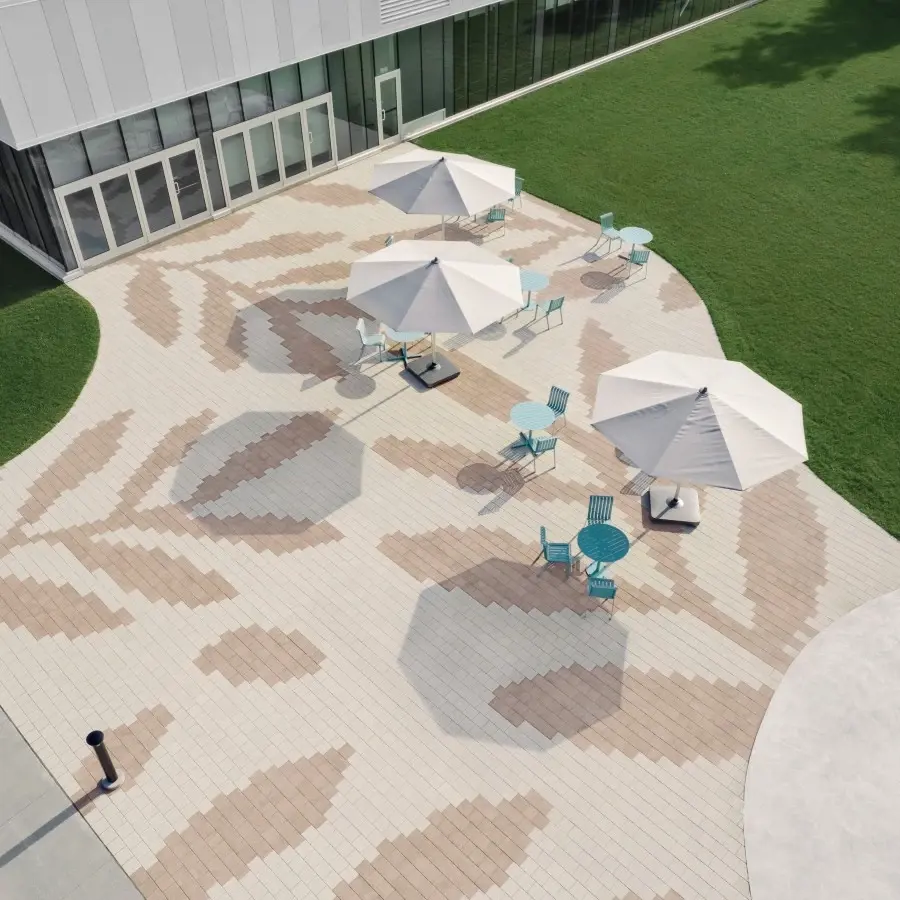 Esplanade extérieure du Campus Community Centre avec des pavés de la collection Industria de Techo-Bloc dans un design géométrique ludique et multicolore.
