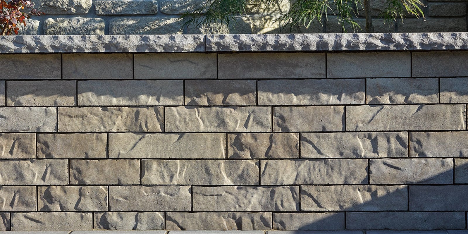 Brandon Wall textured brick-look retaining wall in an outdoor landscape.