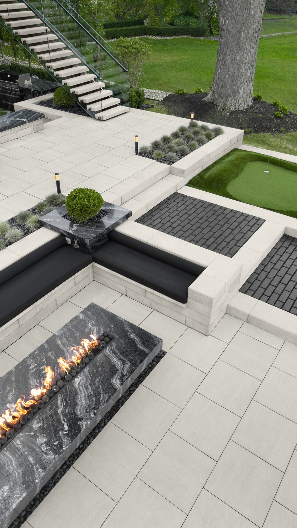 Outdoor seating and fire feature framed by Raffinato steps and installed on Para slabs in a clean modern design.