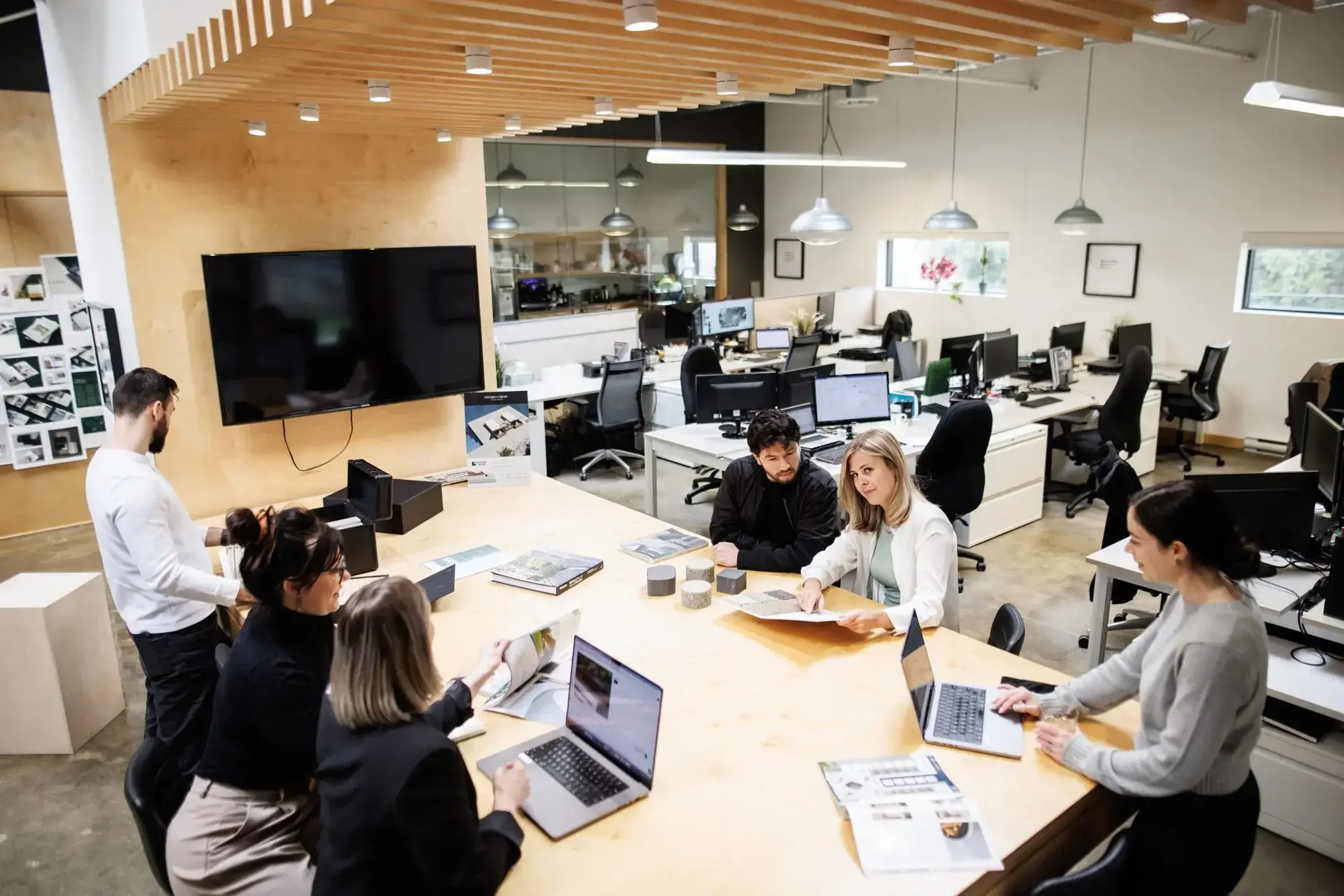 Group of people gathered in a meeting room for a collaborative presentation and discussion.