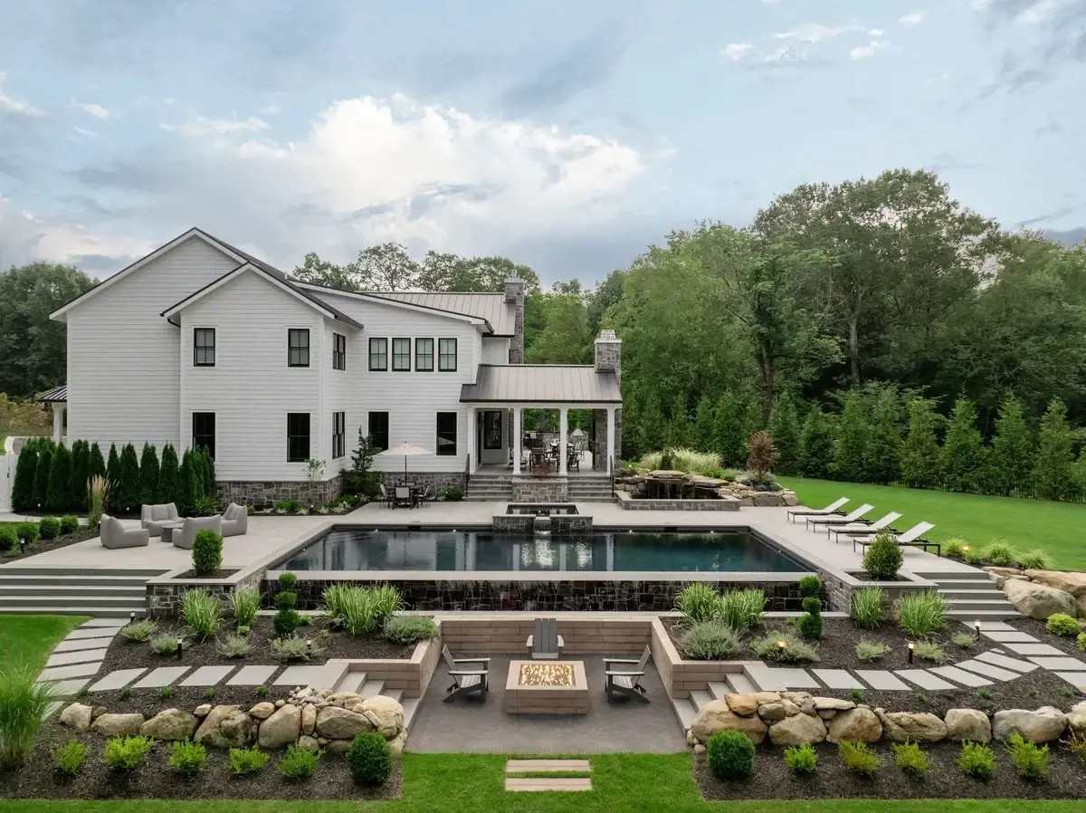 Nature-inspired backyard featuring stone-look Techo-Bloc pavers, layered greenery, and a serene outdoor lounge area.