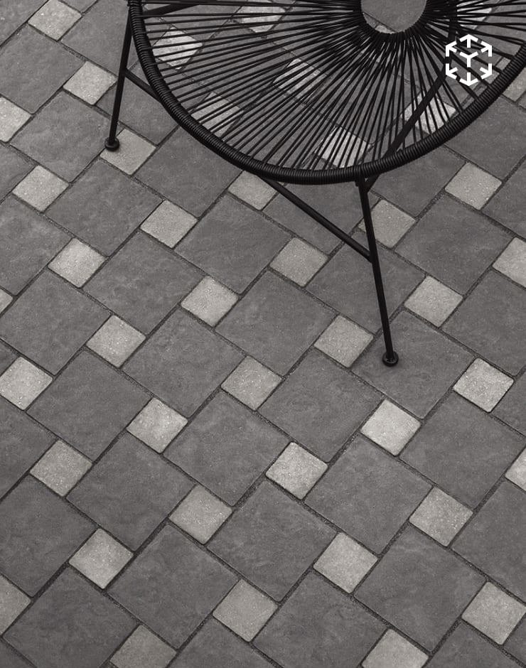 Valet and Squadra mosaic pattern featuring a mixed-tone paver layout in a modern patio setting with minimalist outdoor seating.