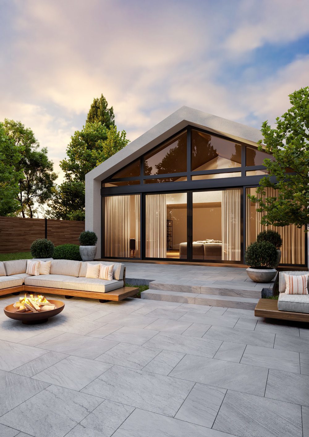 Une terrasse avec des dalles en pierre naturelle de couleur grise, un foyer et des canap&#xE9;s.