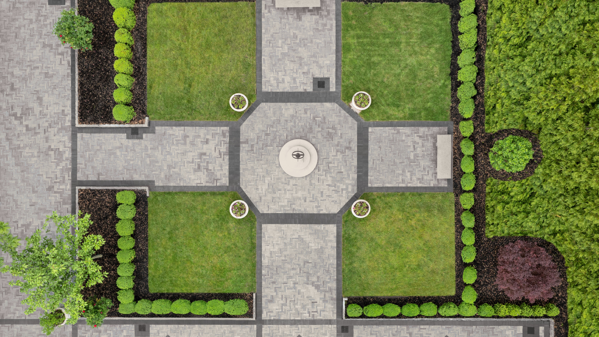 Vue aérienne du Estate at Florentine Gardens avec pavés Westmount en Gris Calcaire et Noir Onyx créant des allées symétriques autour d’une fontaine.