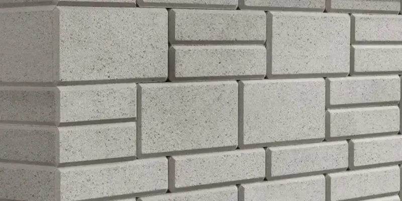 Détail du mur Raffinato Meulé de Techo-Bloc, avec texture de béton polie et légère brillance pour un style architectural contemporain.