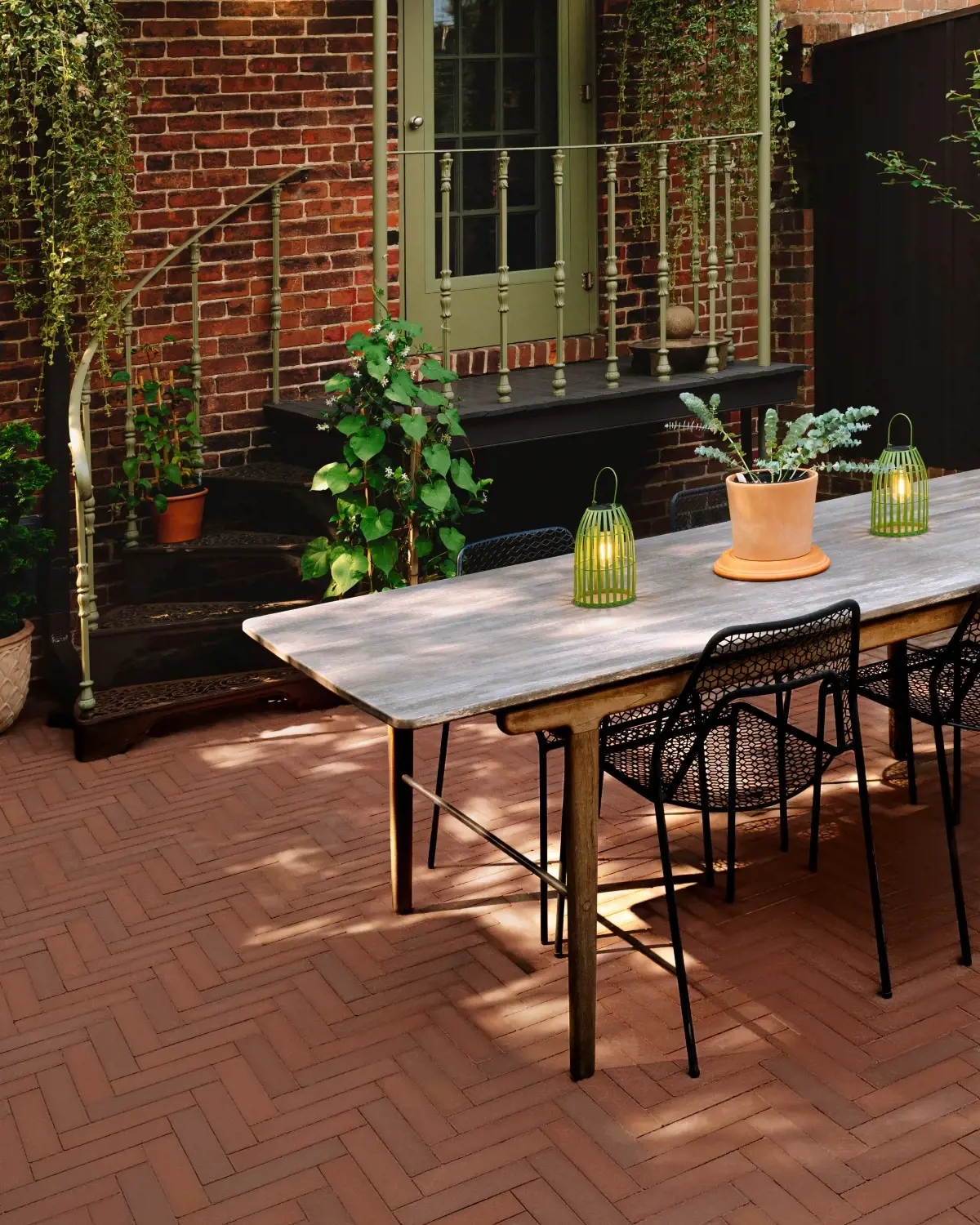 Outdoor dining area in a Richmond backyard featuring Techo-Bloc Westmount pavers in Merlot laid in a herringbone pattern.