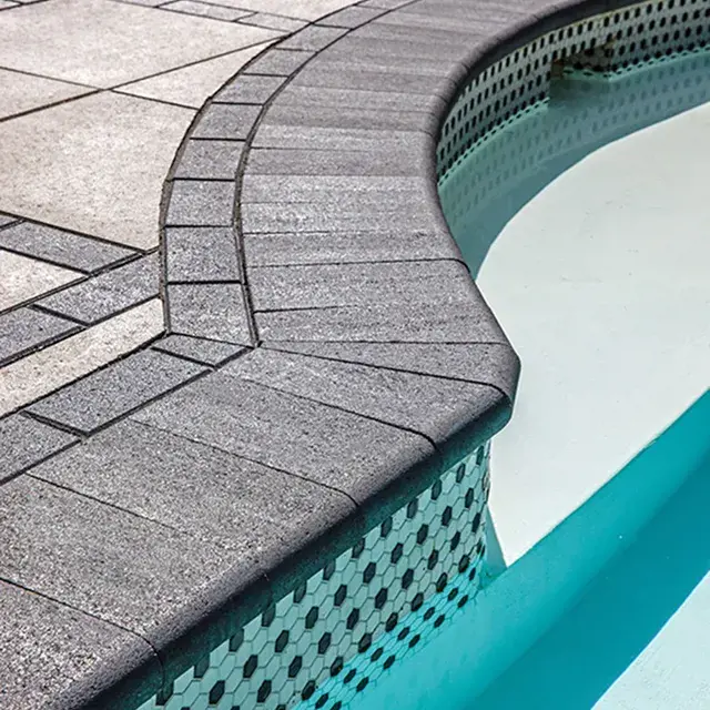 Bullnose by Techo-Bloc, traditional 12x5 concrete pool cap with rounded edges, providing a smooth, classic finish for pool coping and wall tops.