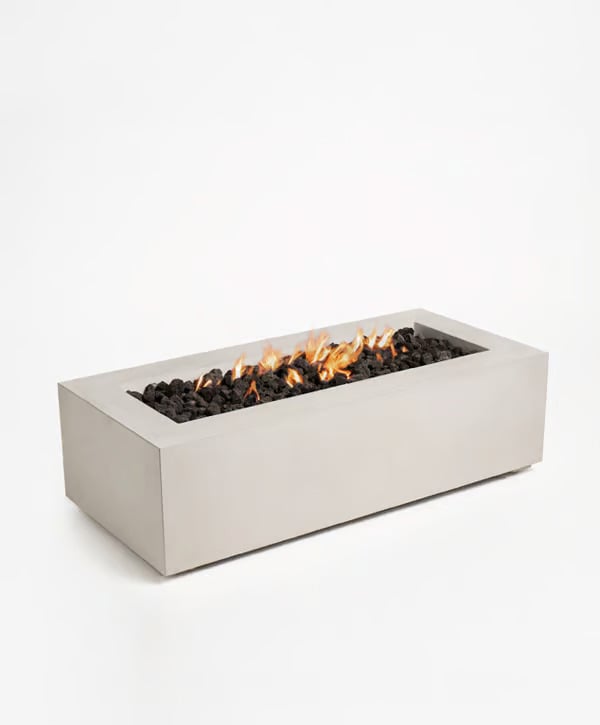 Sculptura Rectangle Fire Pit featuring a long rectangular concrete body with flames rising above black fire stones.
