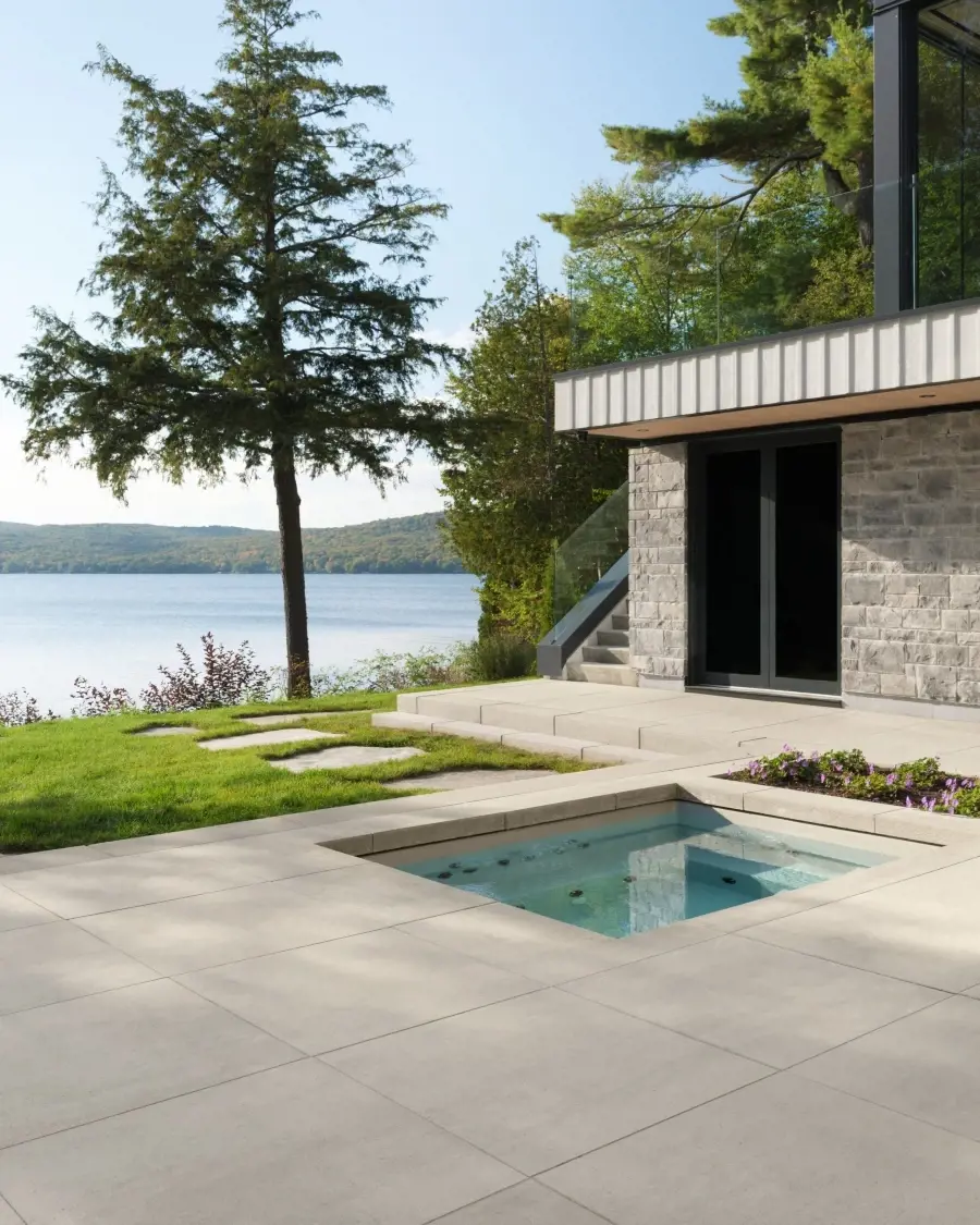 Tranquil poolside setting with expansive paving and open views, creating a restorative outdoor environment focused on relaxation and balance.