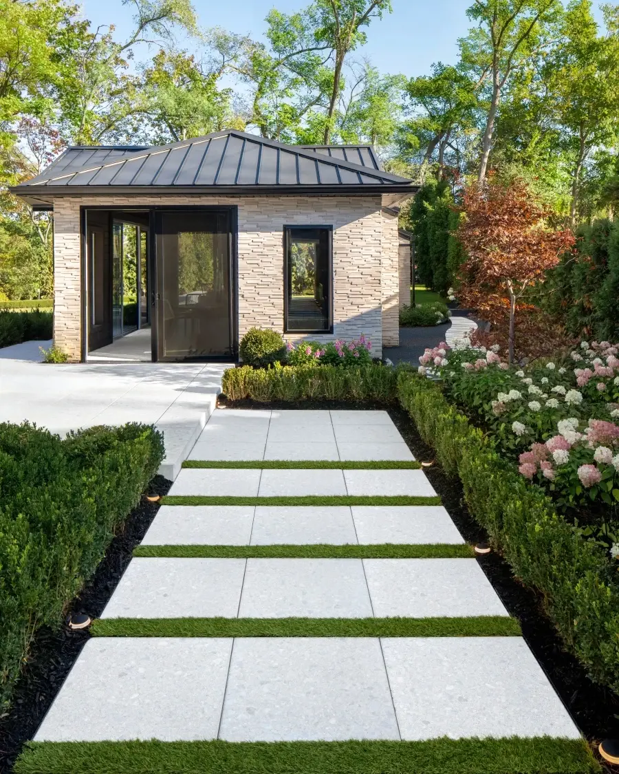 Outdoor walkway designed with Terrazzo slabs in Mineral White, creating a crisp, contemporary path softened by greenery and garden borders.