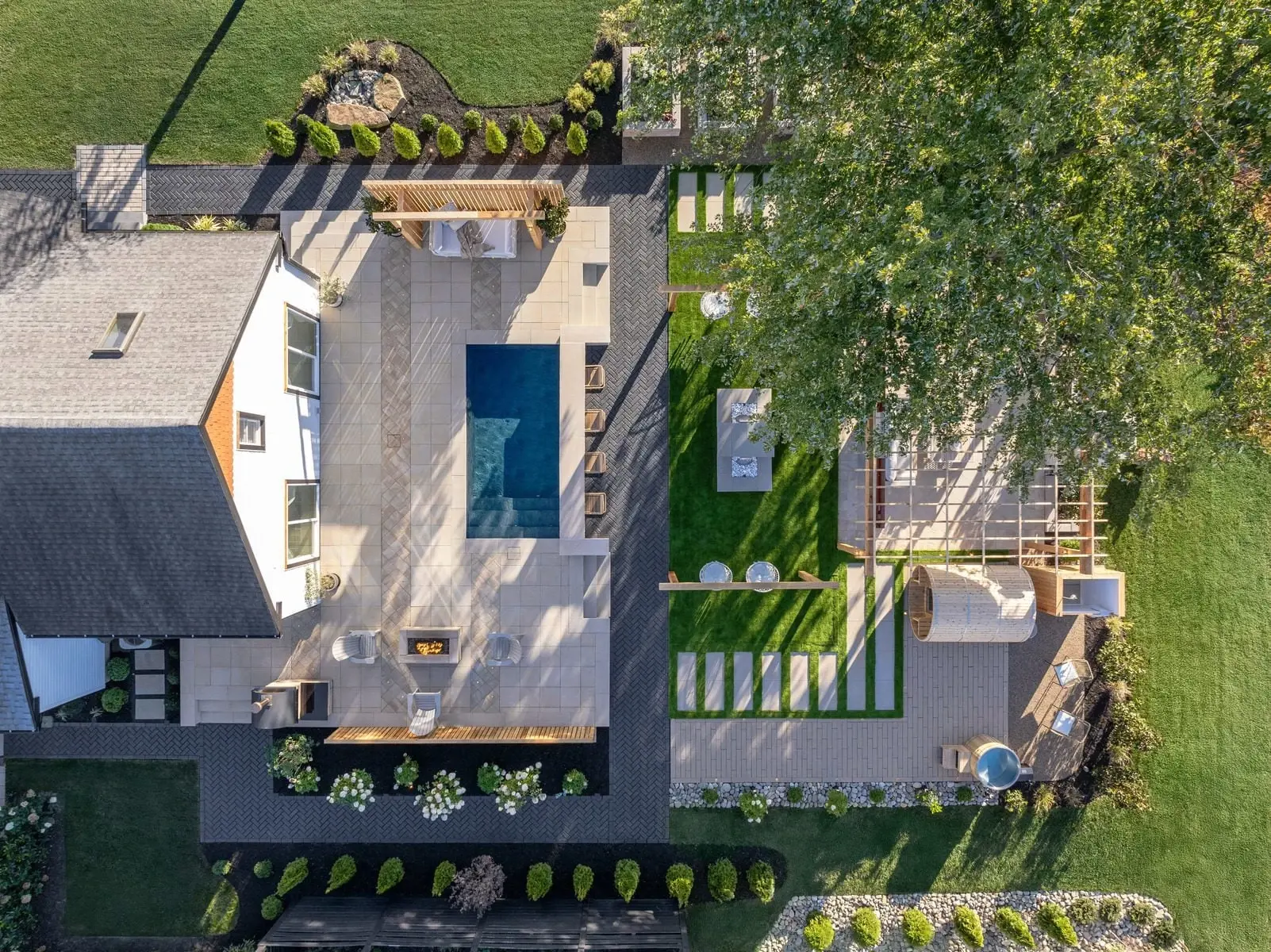 Spa-inspired backyard with modern paver patterns, lush greenery, and peaceful garden walkways.