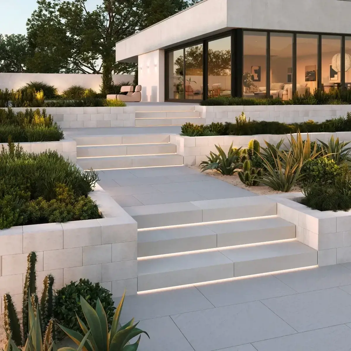 Terraced light-integrated concrete steps leading to a modern home, framed by desert planting, at dusk