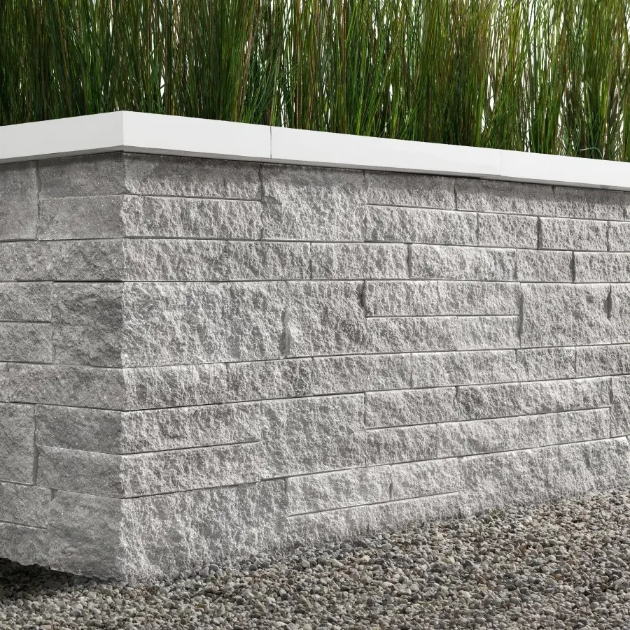 Mur Mini-Creta par Techo-Bloc en Nickel Grisé, avec couronnement blanc, en bordure de jardin moderne.