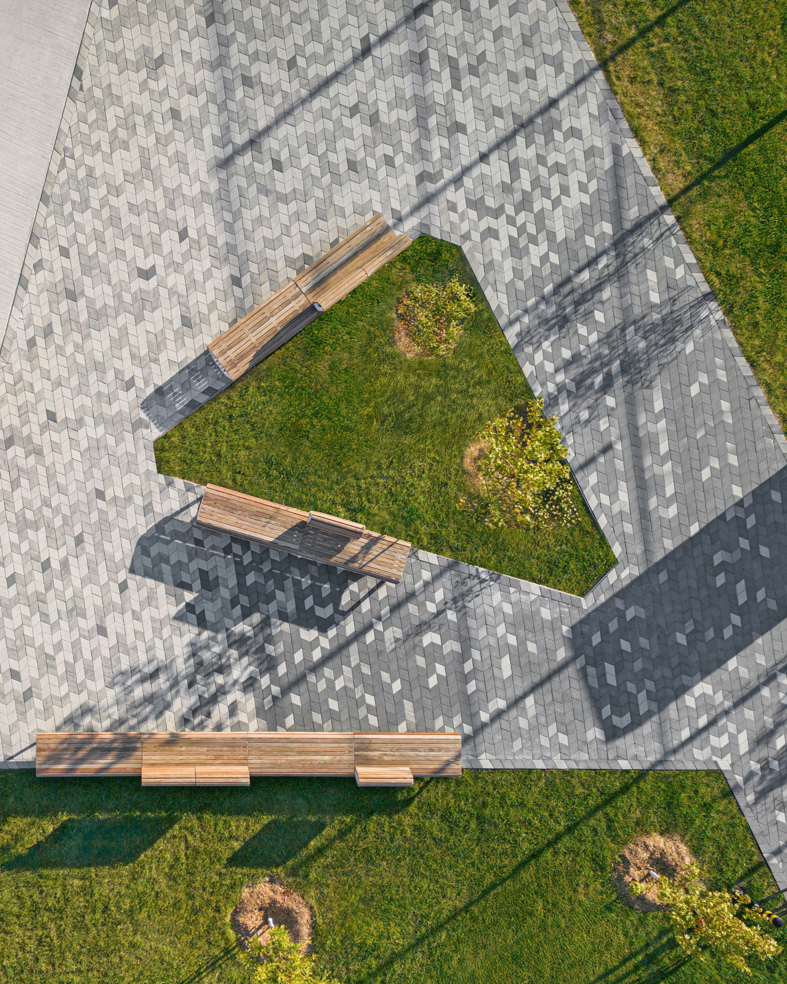 Vue aérienne du motif en chevrons avec pavés Diamond HD² Smooth, bancs et espace vert triangulaire au parc Philippe-Villeneuve.