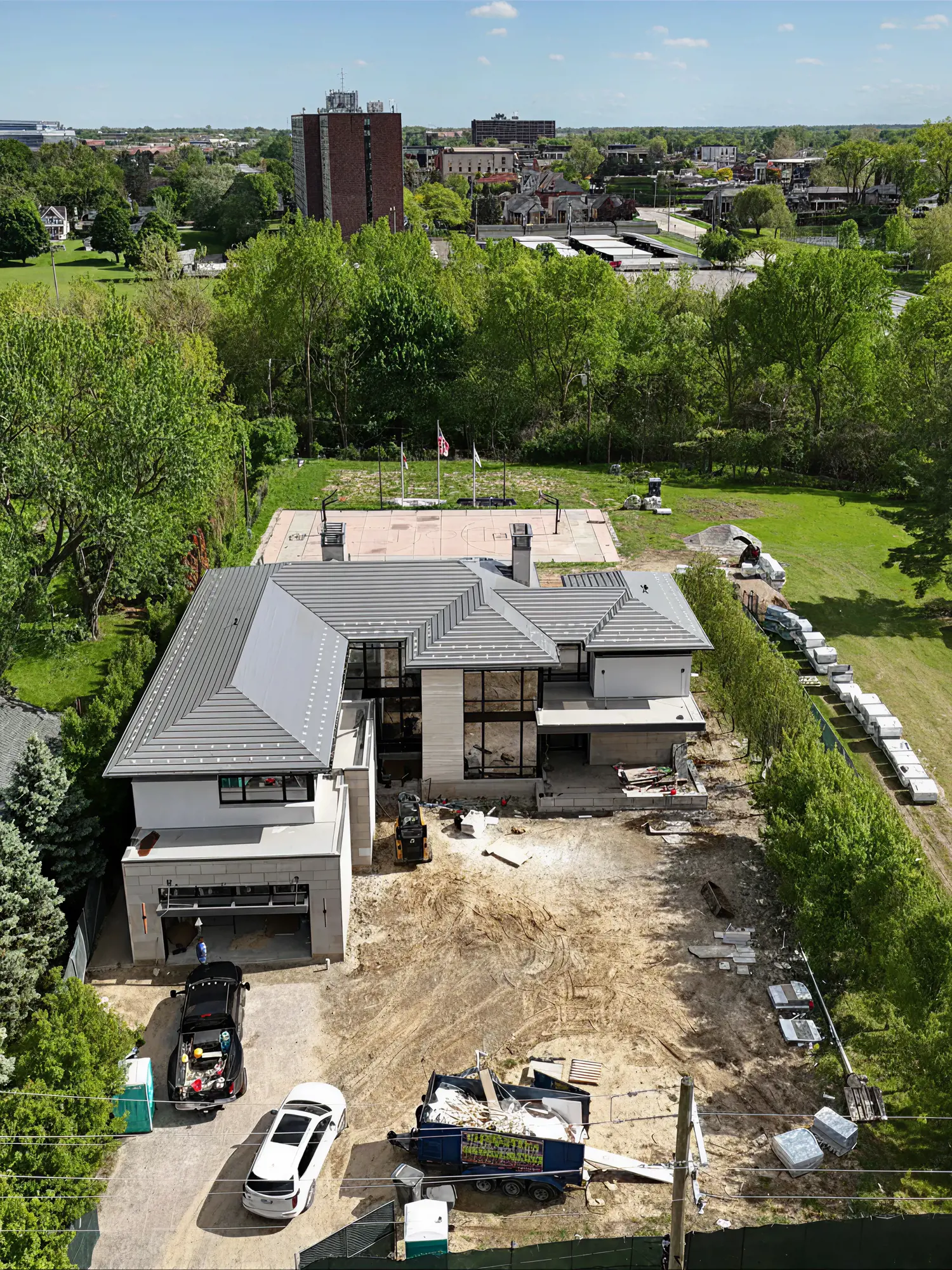 Vue aérienne de la maison avant les travaux, cour de terre nue et matériaux de chantier