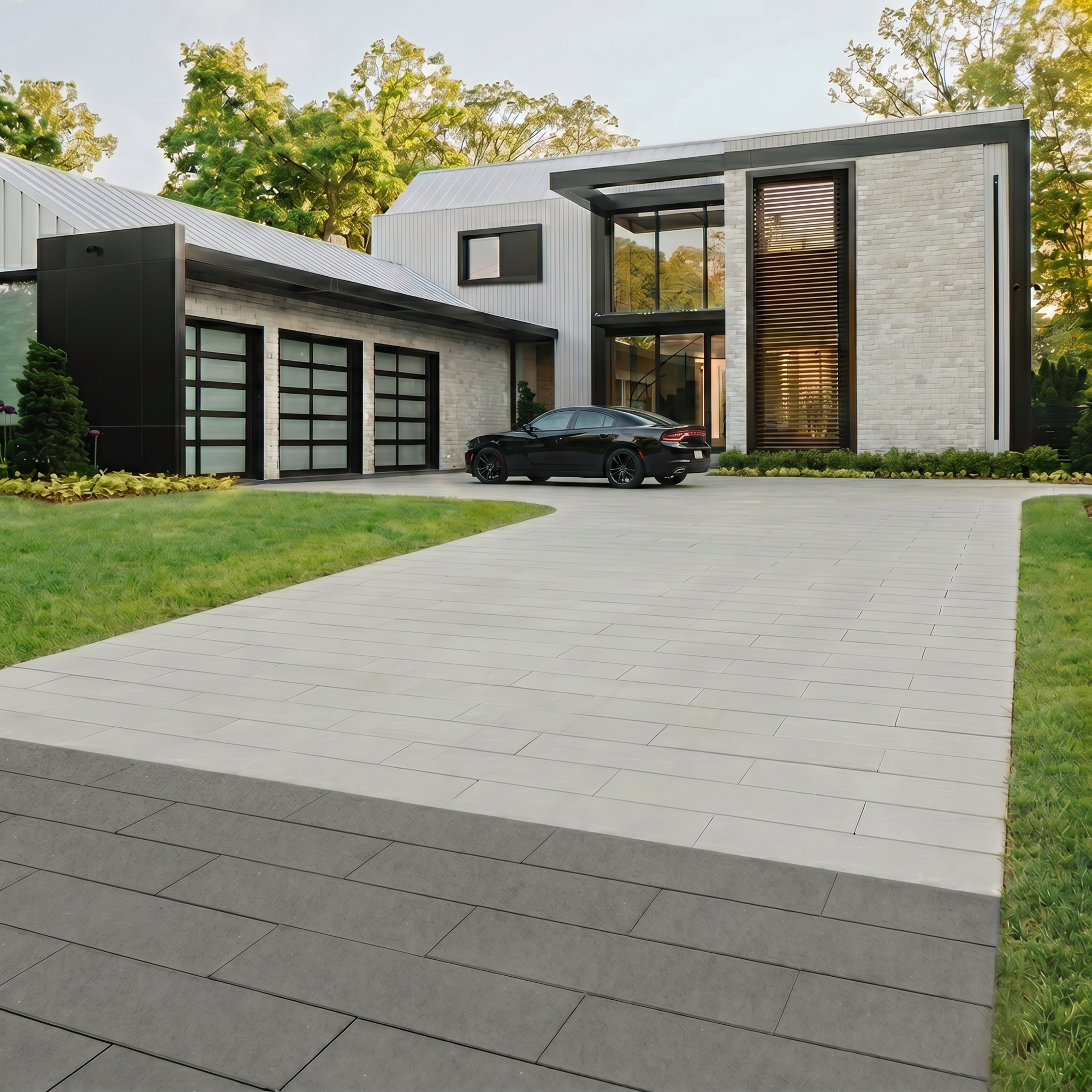 Industria Smooth paver in Greyed Nickel forming a large-format driveway leading to a modern home