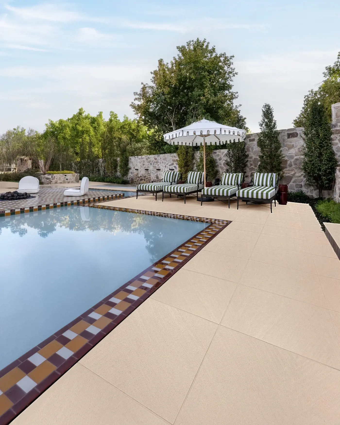 Poolside patio designed with large-format Sandstone slabs in beige, creating a refined and timeless outdoor living space.