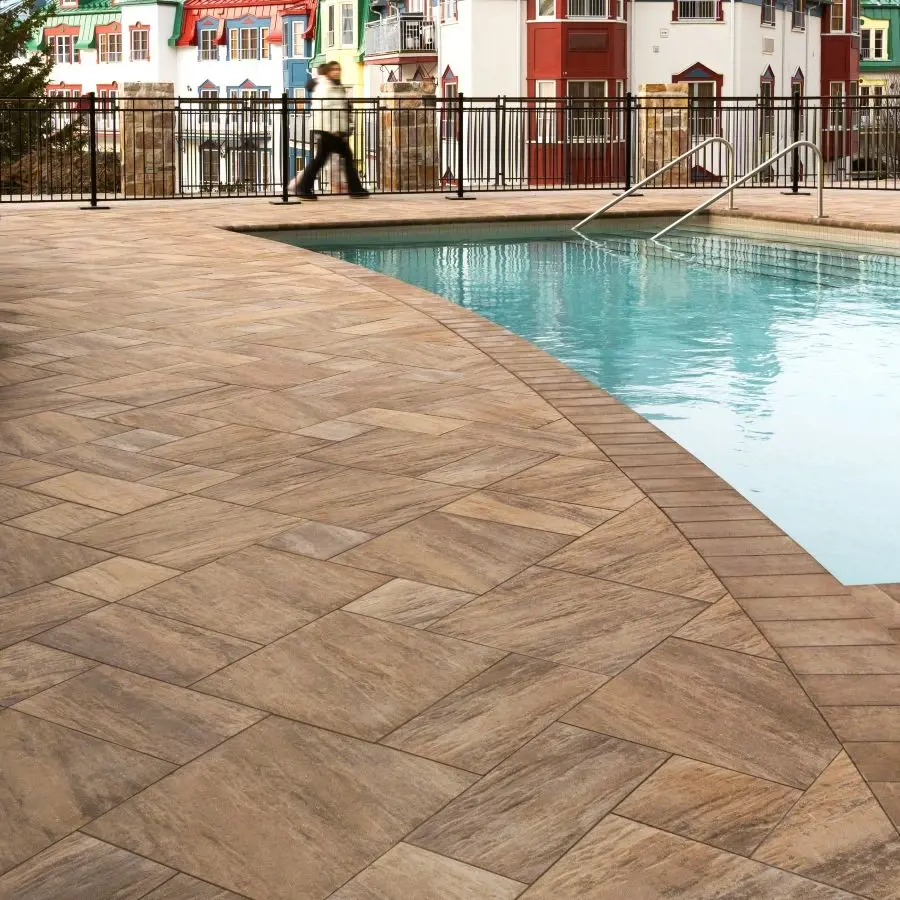 Terrasse au bord de la piscine du Fairmont Tremblant avec un design alpin, mettant en valeur les pavés Everest HD² Slate de Techo-Bloc pour un luxe quatre saisons.