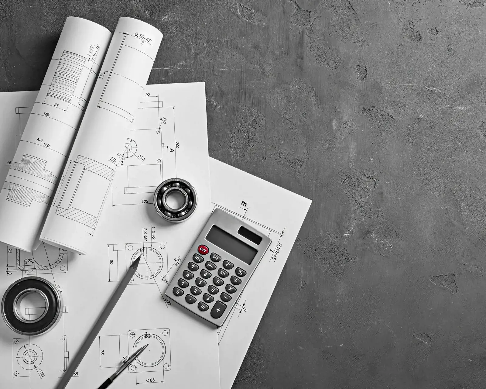 Plans d’architecture avec outils de dessin et calculatrice sur une surface grise, représentant la planification de projets et le soutien commercial.