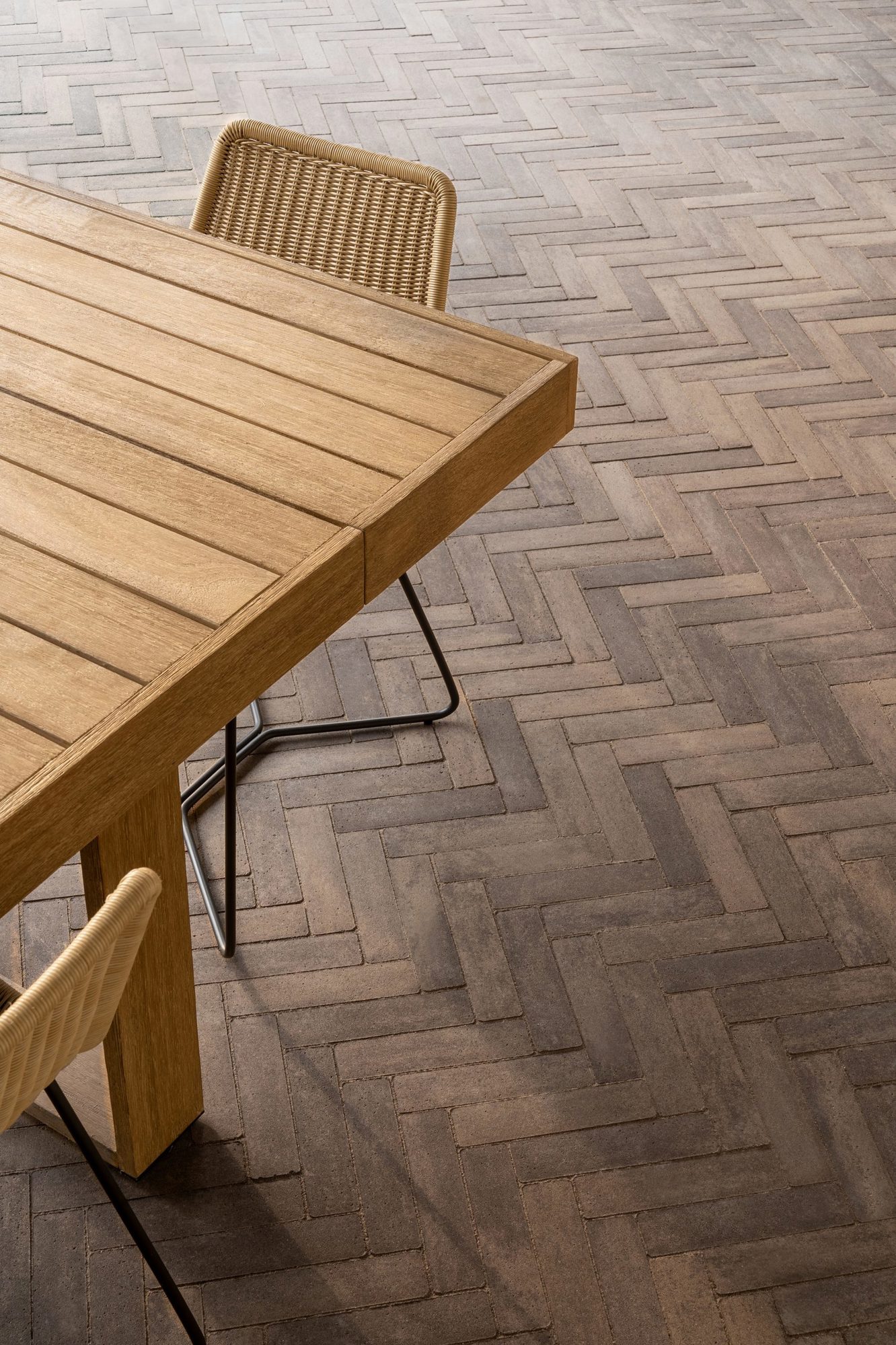 Coin détente sur pavés Westmount couleur Brun Châtaigne avec rideaux légers et textures aux tons terreux pour créer un refuge extérieur accueillant.