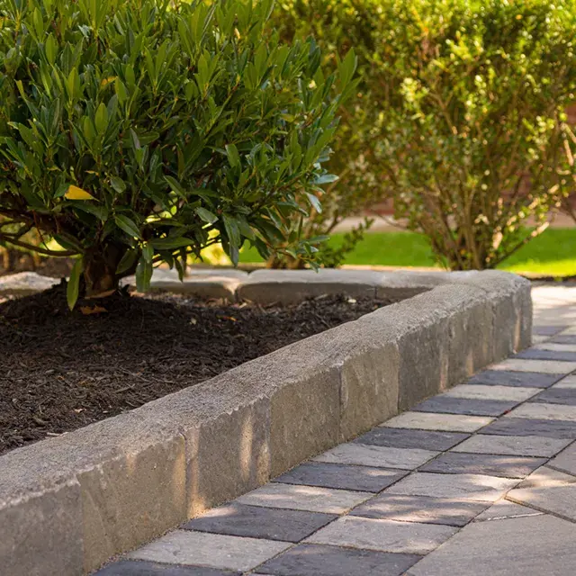 Avignon by Techo-Bloc, slate-textured landscape edging stones, perfect for creating clean, natural borders around garden beds and mulch areas.