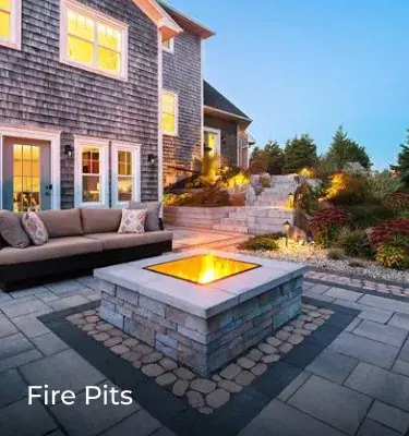 Antika pavers by Techo-Bloc form a cozy patio with Raffinato wall blocks around a central fire pit.