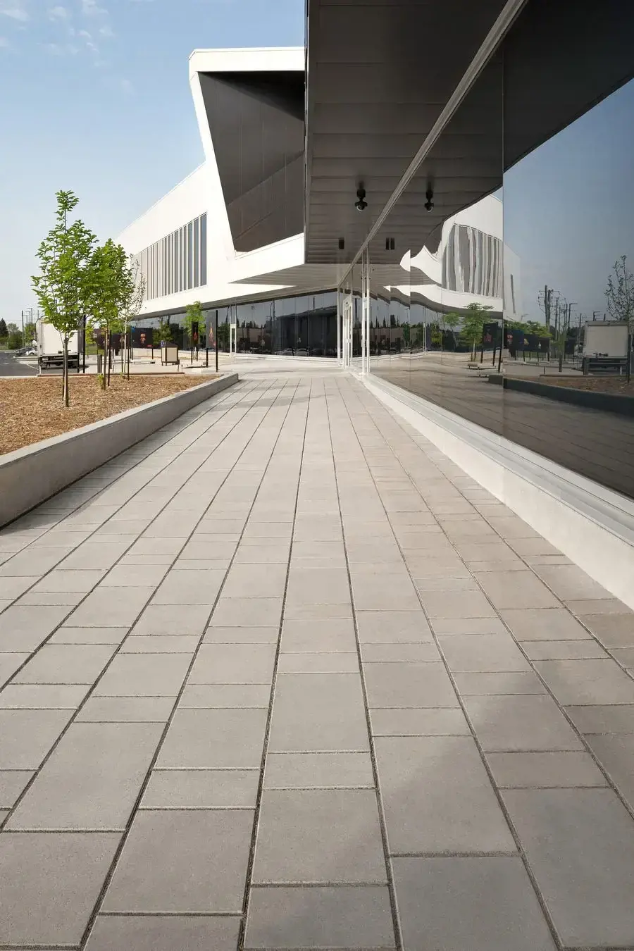 Modern public building with a wide pedestrian walkway surfaced in Techo-Bloc Blu 80 pavers.