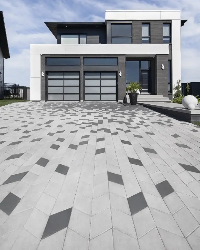 Modern driveway using Techo‑Bloc Diamond Paver in grey and black tones, forming a geometric interlocking pattern. 
