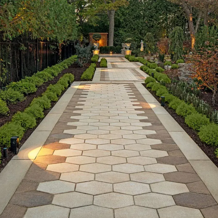 Hexa 60 Slab by Techo-Bloc in Greyed Nickel with hexagonal pattern, offering a modern patio near a fire pit and outdoor lounge.