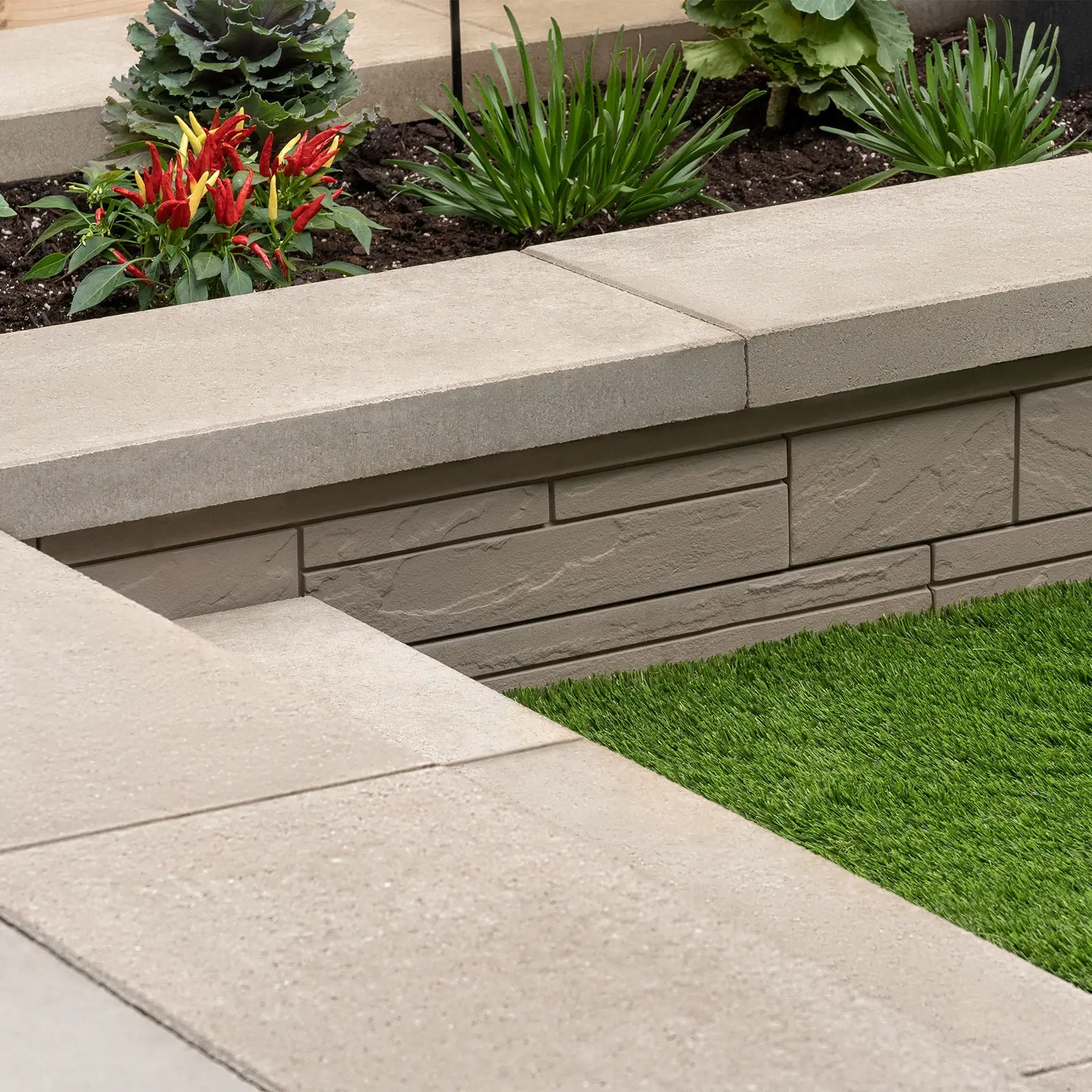 Raffinato Cap in Beige Cream on a planter wall with ornamental grass