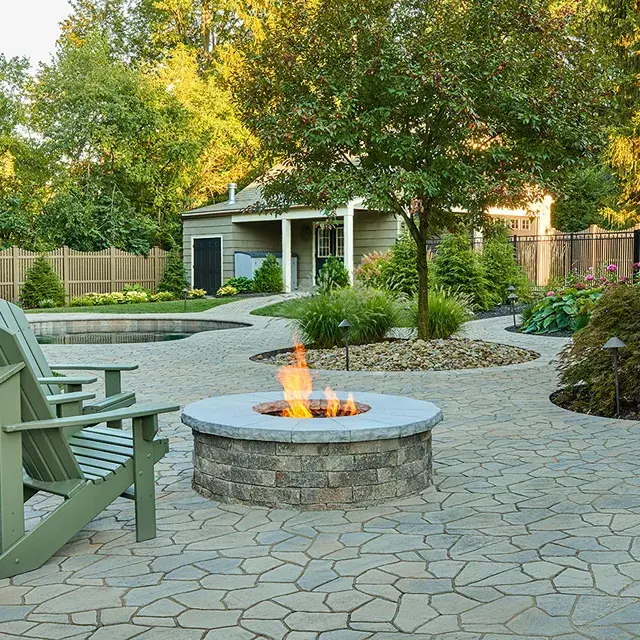Valencia Fire Pit by Techo-Bloc, round stone fire pit, perfect for patios, offering a modern design with multiple color options for outdoor spaces.
