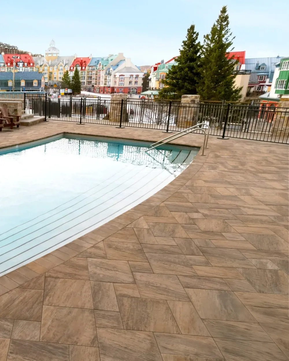 Terrasse du Fairmont Tremblant avec chaises longues, pavée en dalles Everest HD² Ardoise Brun Châtaigne de Techo-Bloc pour élégance et durabilité.