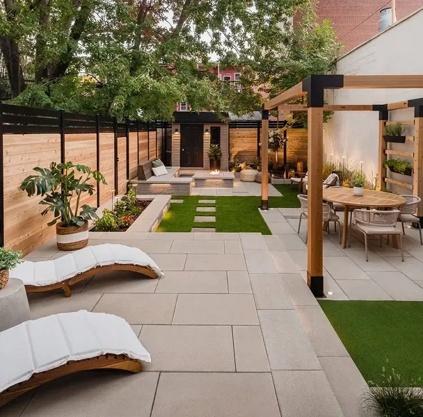 Cour arrière avec patio moderne, chaises longues, pergola en bois et coin repas extérieur.