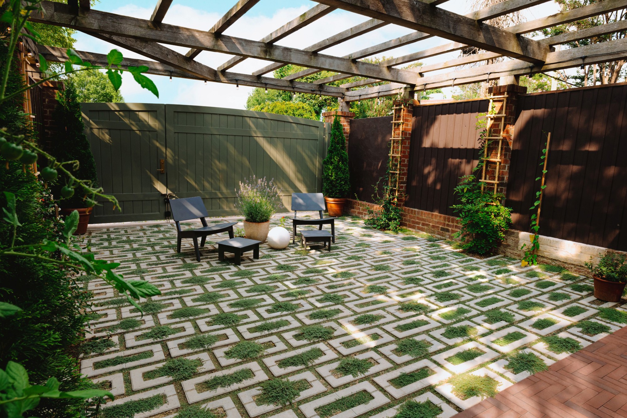Modern backyard patio in Richmond, Virginia featuring Techo-Bloc Aquastorm permeable pavers in a geometric pattern with grass inlays, creating a calm outdoor seating and dining space.