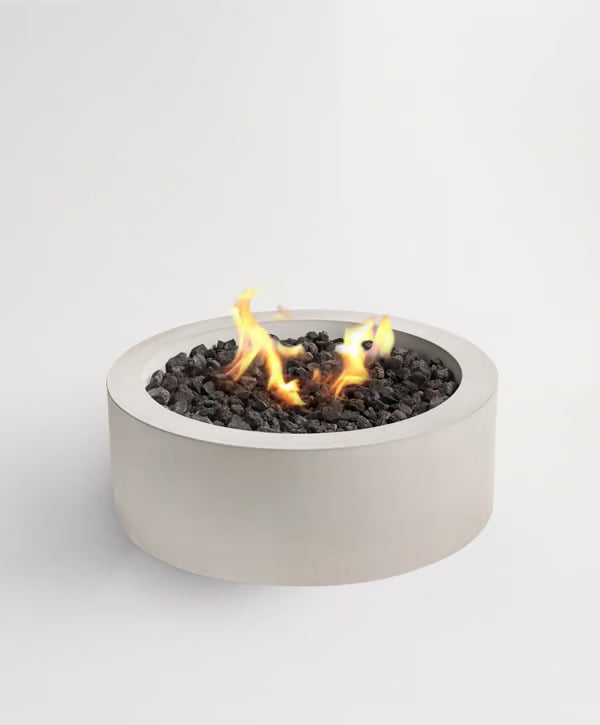 Sculptura Circle Fire Pit with a round smooth concrete design and central flame surrounded by black fire stones.