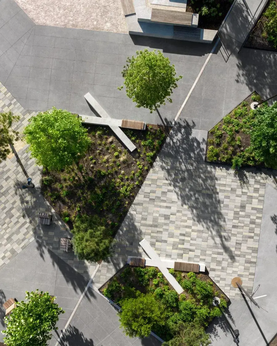 Vue aérienne d’un aménagement extérieur moderne avec pavés Techo-Bloc, arbres et bancs.