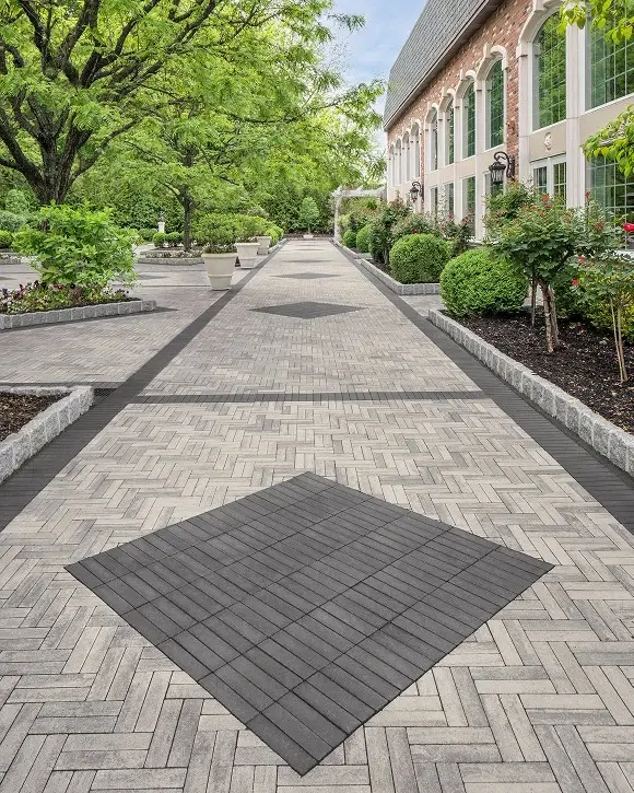 Les Florentine Gardens pavés en Westmount de Techo-Bloc avec pose en chevron, créant une cour d’hospitalité élégante et intemporelle.