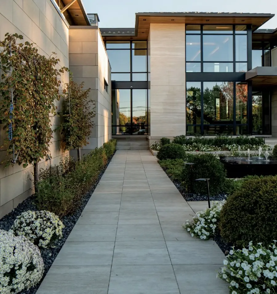 Contemporary residential walkway with large-format concrete slabs and minimalist landscaping.